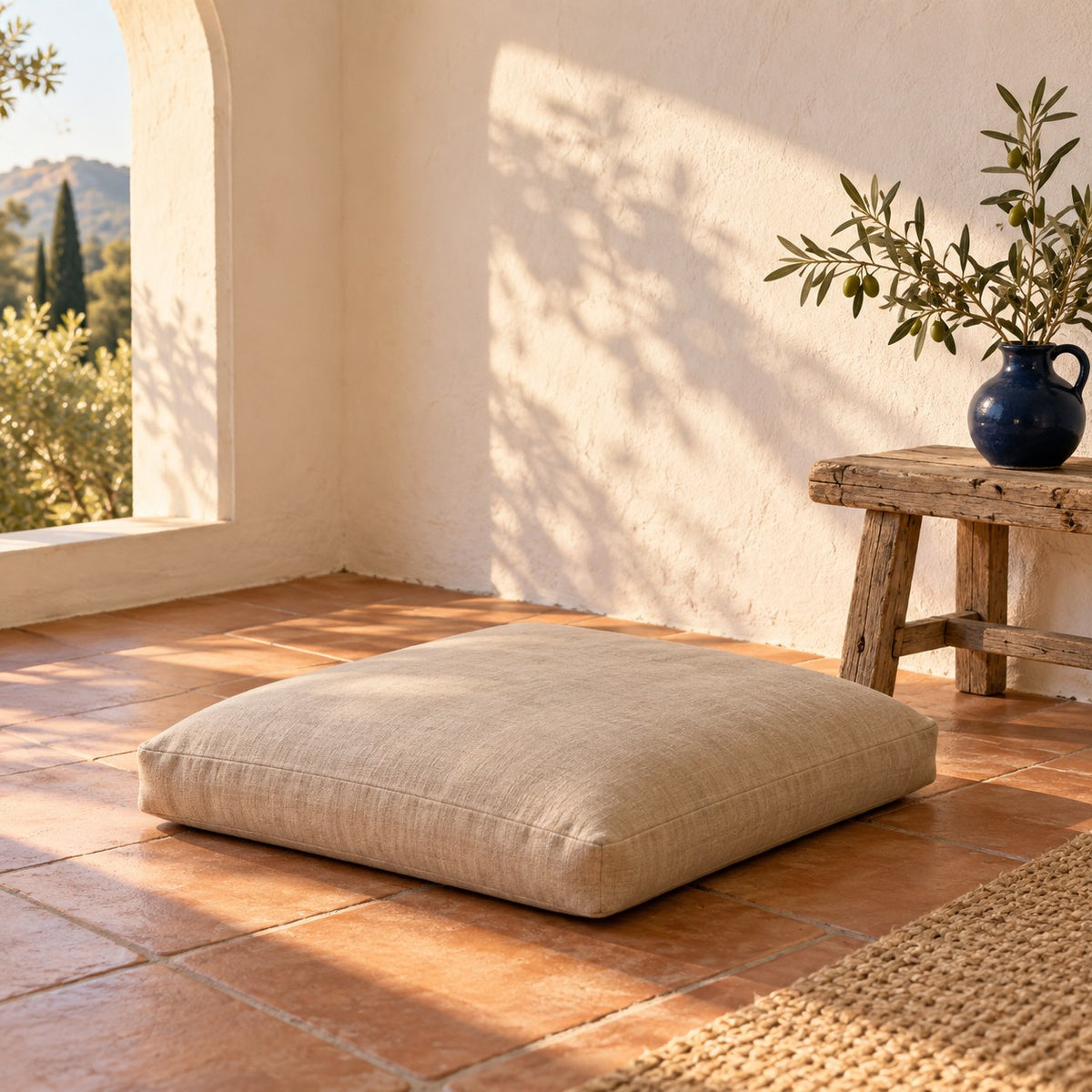 Meditation cushion on a terracotta floor in a sunlit Andalusian room