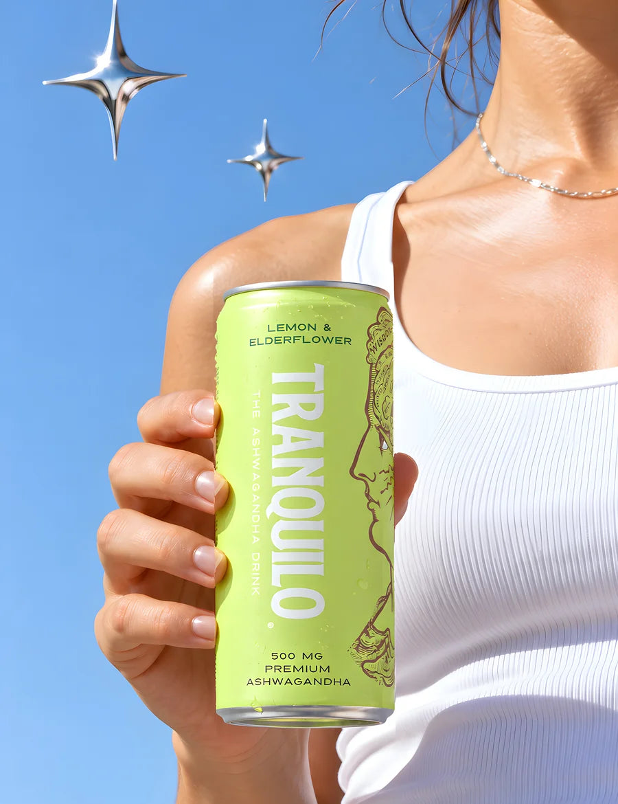 A hand holding a can of Tranquilo Lemon & Elderflower