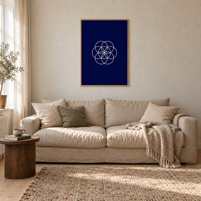 Poster Bloom, navy, in an oak frame above a linen sofa