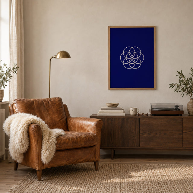 Poster Bloom, navy, in an oak frame beside a leather armchair