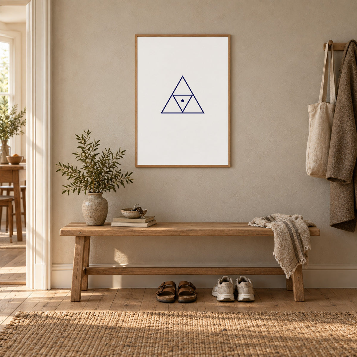 Poster Triad, white, in an oak frame above a hallway bench